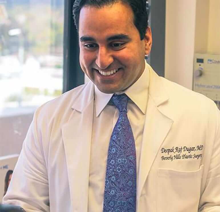 Dr. Deepak Dugar, best plastic surgeon in Beverly Hills, CA smiling to a patient